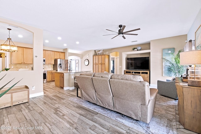 5337 Indigo Crossing Dr, Rockledge, FL 32955 - living room with arched walkways, a ceiling fan, light wood-type flooring, and recessed lighting
