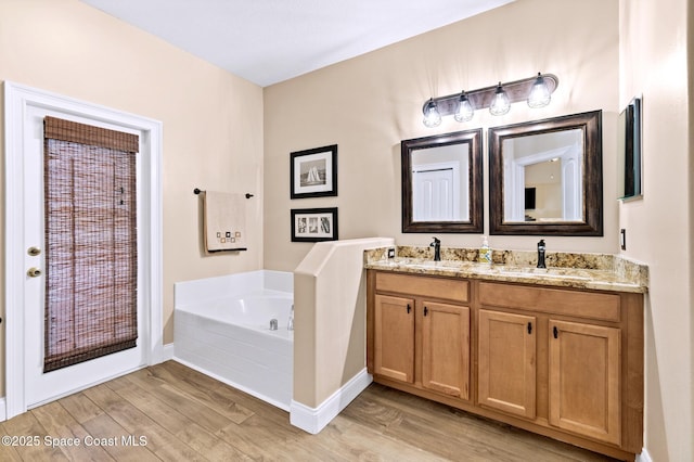 5337 Indigo Crossing Dr, Rockledge, FL 32955 - bathroom with double vanity, wood finished floors, and a bath