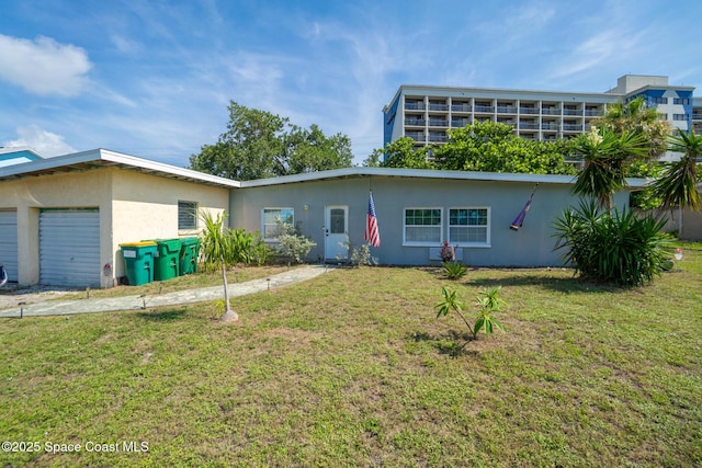 113 Surf Dr, Cocoa Beach, FL 32931 - view of front facade with stucco siding, a front yard, and a garage