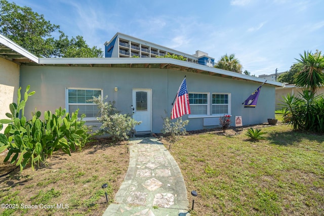 113 Surf Dr, Cocoa Beach, FL 32931 - view of front of house featuring stucco siding and a front yard