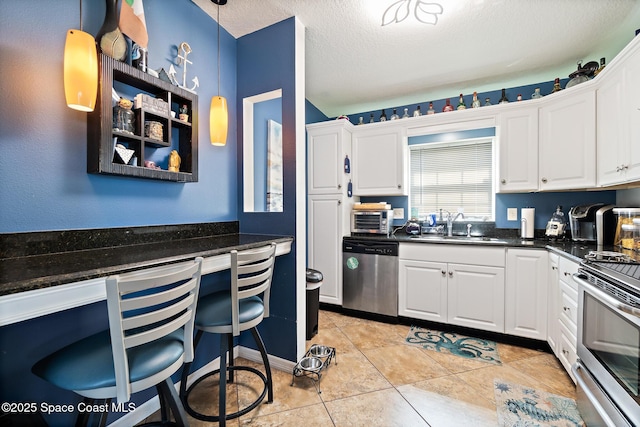 113 Surf Dr, Cocoa Beach, FL 32931 - kitchen featuring stainless steel appliances, white cabinetry, light tile patterned floors, a textured ceiling, and dark stone counters