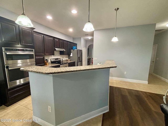 3725 Aria Dr, Melbourne, FL 32904 - kitchen featuring appliances with stainless steel finishes, under cabinet range hood, backsplash, hanging light fixtures, and recessed lighting