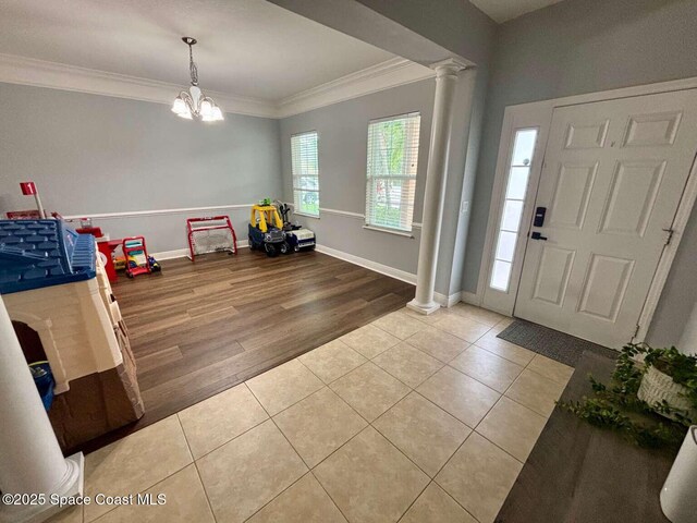3725 Aria Dr, Melbourne, FL 32904 - tiled entrance foyer with ornate columns, crown molding, and a chandelier