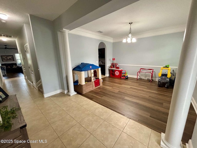 3725 Aria Dr, Melbourne, FL 32904 - rec room featuring ornamental molding, tile patterned flooring, ornate columns, arched walkways, and a chandelier