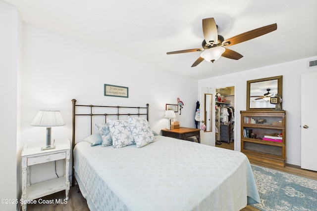 3190 N Atlantic Ave Unit 220, Cocoa Beach, FL 32931 - bedroom featuring wood finished floors, a walk in closet, and a ceiling fan