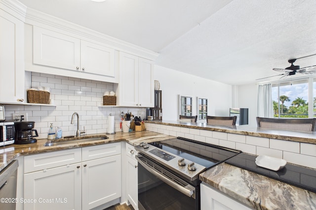 3190 N Atlantic Ave Unit 220, Cocoa Beach, FL 32931 - kitchen with stainless steel appliances, decorative backsplash, white cabinets, light stone countertops, and ceiling fan