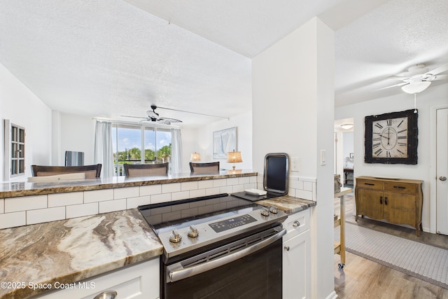 3190 N Atlantic Ave Unit 220, Cocoa Beach, FL 32931 - kitchen featuring stainless steel electric range, ceiling fan, a textured ceiling, and white cabinets