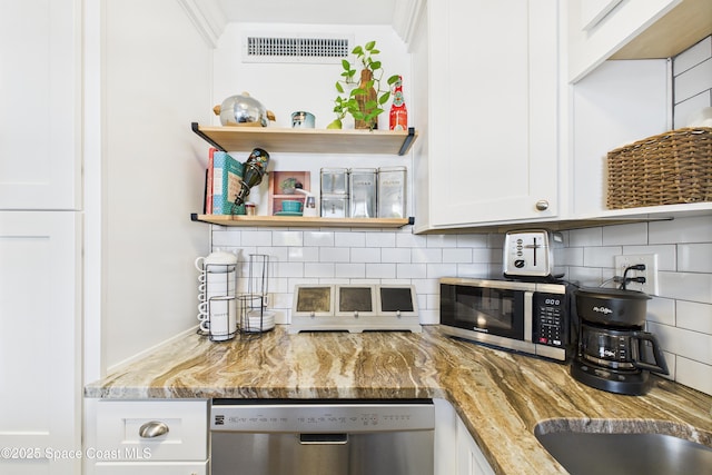3190 N Atlantic Ave Unit 220, Cocoa Beach, FL 32931 - kitchen with stainless steel appliances, decorative backsplash, white cabinets, and light stone counters