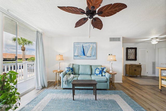 3190 N Atlantic Ave Unit 220, Cocoa Beach, FL 32931 - living area featuring a ceiling fan, wood finished floors, and a textured ceiling