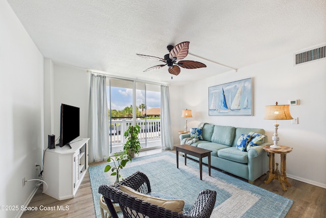 3190 N Atlantic Ave Unit 220, Cocoa Beach, FL 32931 - living room featuring light wood-type flooring, a textured ceiling, and a ceiling fan