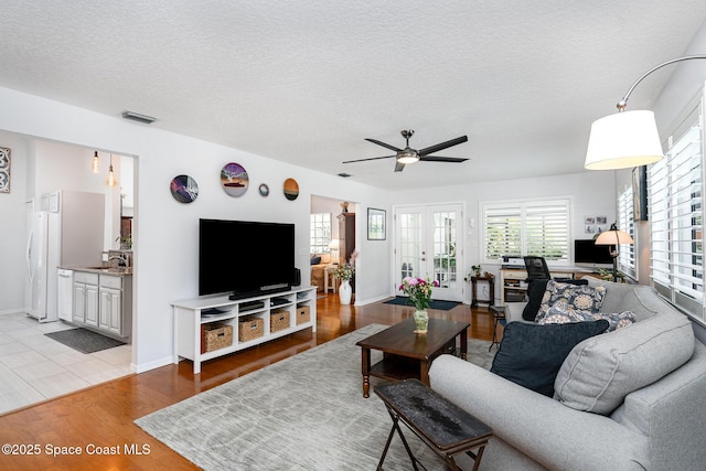1453 Goldrush Ave, Melbourne, FL 32940 - living area featuring healthy amount of natural light, a ceiling fan, wood finished floors, and a textured ceiling