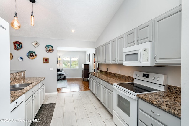 1453 Goldrush Ave, Melbourne, FL 32940 - kitchen with white appliances, hanging light fixtures, vaulted ceiling, dark stone countertops, and recessed lighting