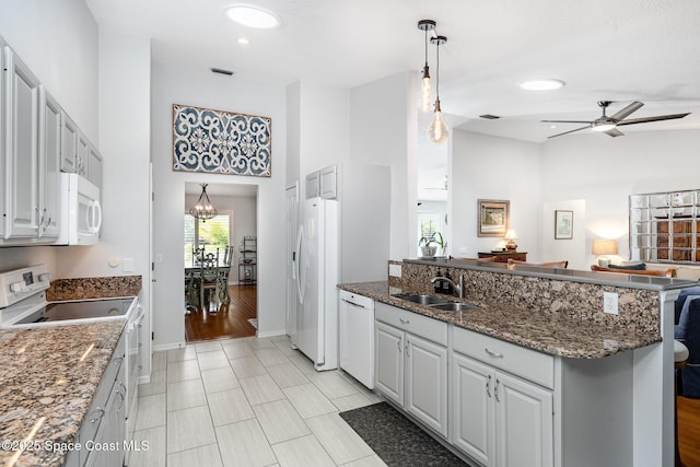 1453 Goldrush Ave, Melbourne, FL 32940 - kitchen featuring white appliances, a high ceiling, ceiling fan, a peninsula, and dark stone countertops