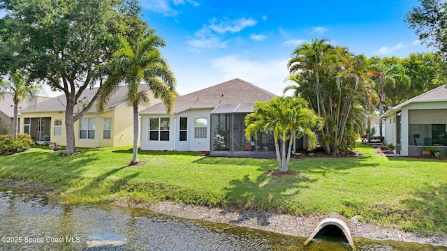 4490 Portage Trl, Melbourne, FL 32940 - back of property featuring a yard, stucco siding, a sunroom, and a water view