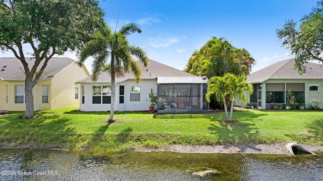 4490 Portage Trl, Melbourne, FL 32940 - back of house featuring a water view, stucco siding, a yard, and a sunroom