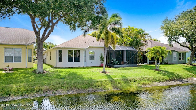 4490 Portage Trl, Melbourne, FL 32940 - back of house with stucco siding, a water view, a lawn, and glass enclosure