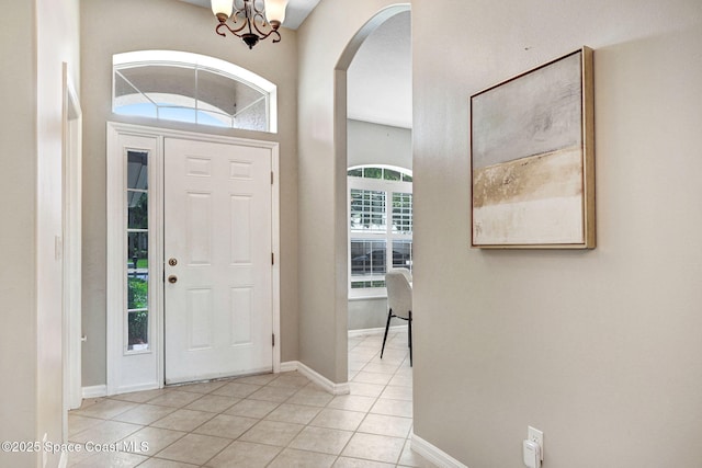 4490 Portage Trl, Melbourne, FL 32940 - entrance foyer featuring light tile patterned floors, arched walkways, and a chandelier