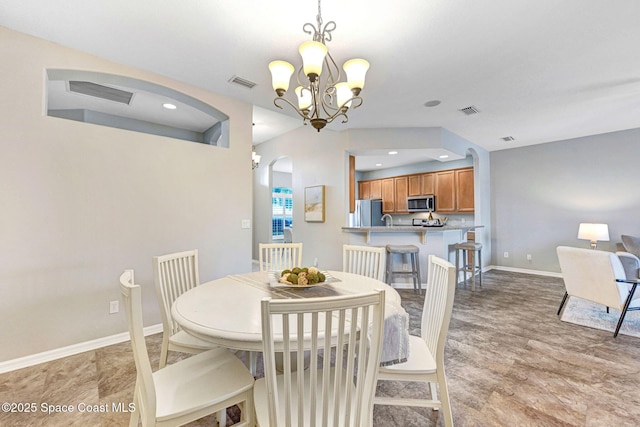 4490 Portage Trl, Melbourne, FL 32940 - dining space with arched walkways, a chandelier, recessed lighting, and light wood-type flooring