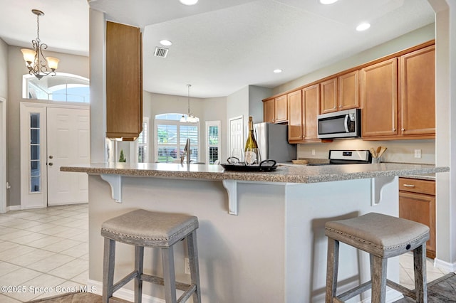 4490 Portage Trl, Melbourne, FL 32940 - kitchen with stainless steel appliances, a chandelier, a breakfast bar area, and recessed lighting