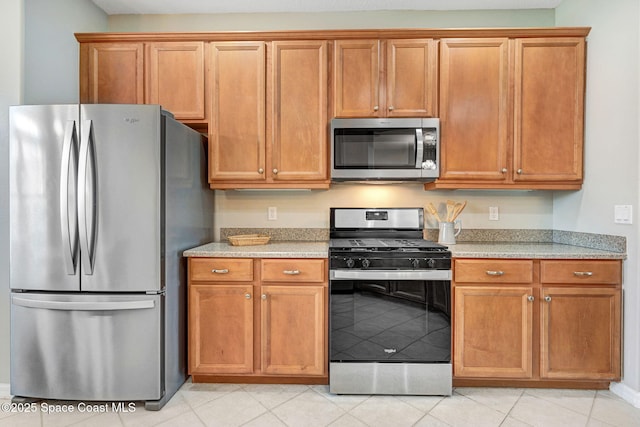 4490 Portage Trl, Melbourne, FL 32940 - kitchen with appliances with stainless steel finishes, brown cabinetry, and light tile patterned floors