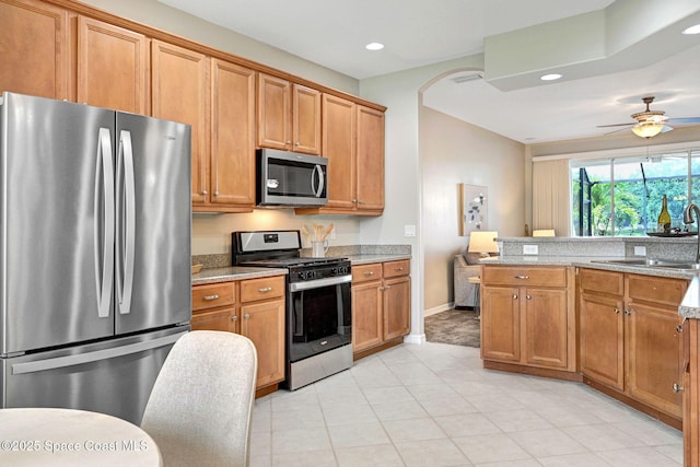 4490 Portage Trl, Melbourne, FL 32940 - kitchen with appliances with stainless steel finishes, recessed lighting, light tile patterned flooring, a ceiling fan, and brown cabinets