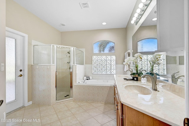 4490 Portage Trl, Melbourne, FL 32940 - bathroom with double vanity, a garden tub, a stall shower, and tile patterned floors