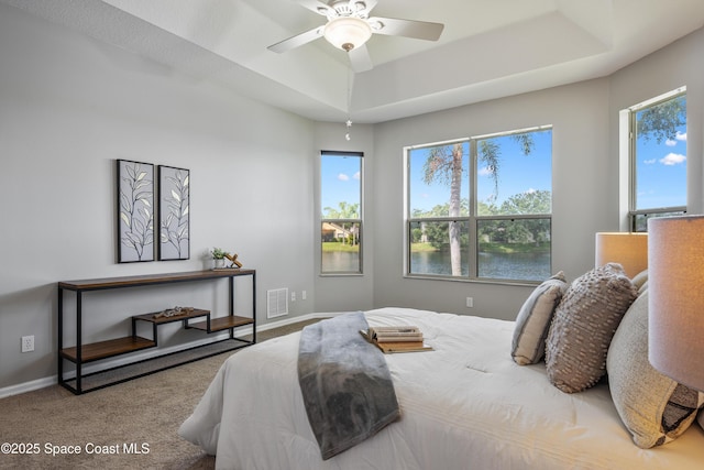 4490 Portage Trl, Melbourne, FL 32940 - bedroom with carpet floors, a tray ceiling, a water view, and ceiling fan