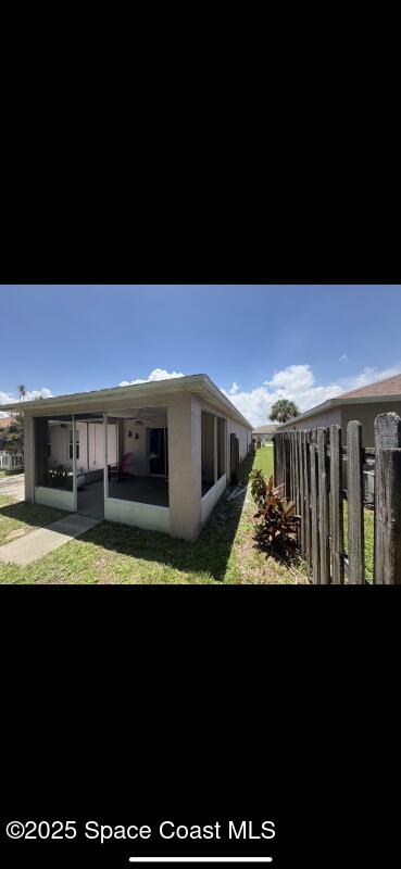 4094 Wilkes Dr, Melbourne, FL 32901 - back of house featuring a sunroom and a lawn
