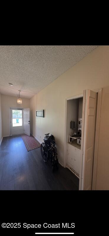 4094 Wilkes Dr, Melbourne, FL 32901 - living room featuring wood finished floors, a textured ceiling, and a chandelier