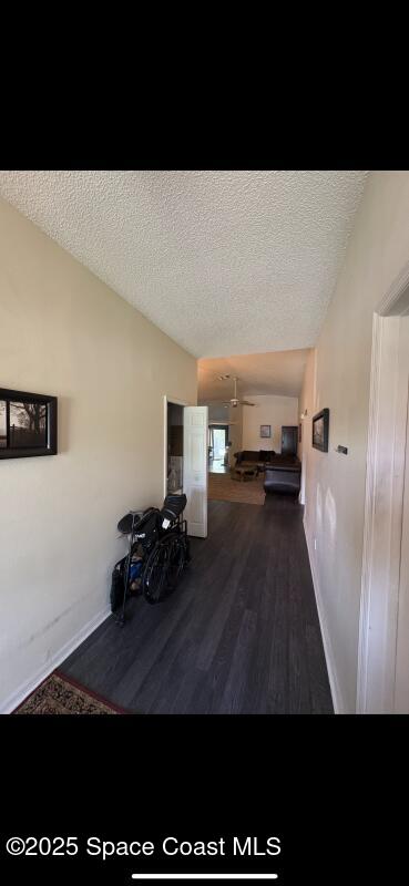 4094 Wilkes Dr, Melbourne, FL 32901 - corridor featuring vaulted ceiling, a textured ceiling, and wood finished floors