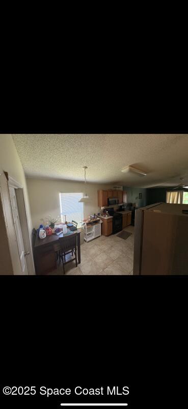4094 Wilkes Dr, Melbourne, FL 32901 - dining space featuring a textured ceiling and healthy amount of natural light
