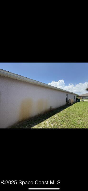 4094 Wilkes Dr, Melbourne, FL 32901 - view of side of property featuring a lawn