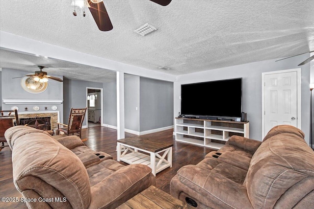 3440 Pine St, Cocoa, FL 32926 - living room featuring a ceiling fan, wood finished floors, a textured ceiling, and a fireplace