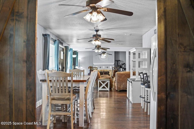 3440 Pine St, Cocoa, FL 32926 - dining room featuring a textured ceiling, ceiling fan, and dark wood-style floors