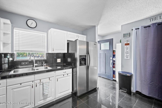 3440 Pine St, Cocoa, FL 32926 - kitchen with stainless steel fridge with ice dispenser, dark countertops, white cabinets, and granite floors