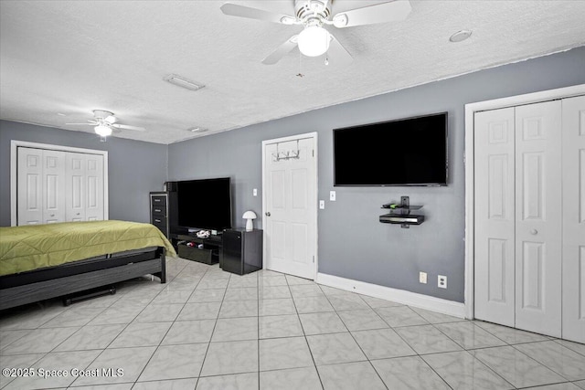 3440 Pine St, Cocoa, FL 32926 - bedroom featuring a textured ceiling, two closets, a ceiling fan, and light tile patterned floors