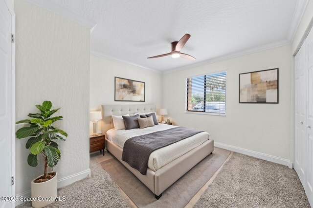 2190 Forest Knoll Dr NE Unit 90-104, Palm Bay, FL 32905 - bedroom with crown molding, carpet, a closet, and ceiling fan