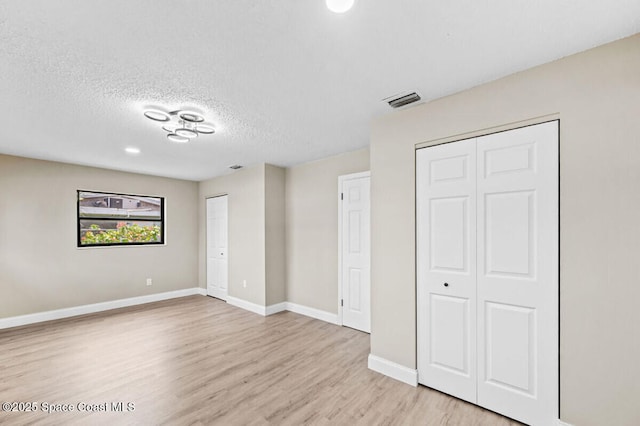532 Buckingham Ave, Melbourne, FL 32935 - unfurnished bedroom featuring light wood finished floors, a textured ceiling, and two closets