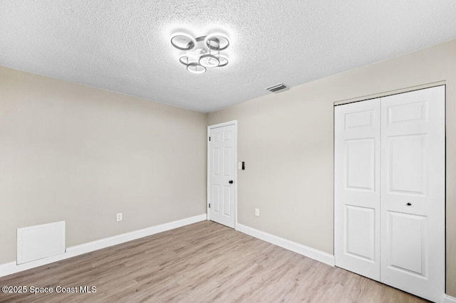532 Buckingham Ave, Melbourne, FL 32935 - unfurnished bedroom featuring wood finished floors, a textured ceiling, and a closet