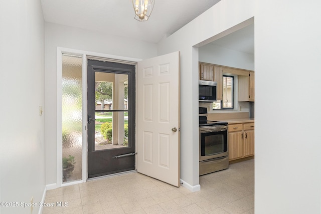 1570 Frontier Dr, Melbourne, FL 32940 - kitchen with appliances with stainless steel finishes, light floors, light countertops, a chandelier, and light brown cabinets