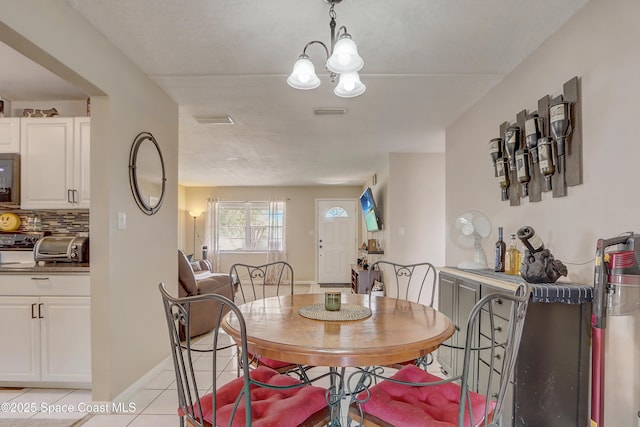 1032 Bernice Rd, Rockledge, FL 32955 - dining space featuring light tile patterned floors and a chandelier