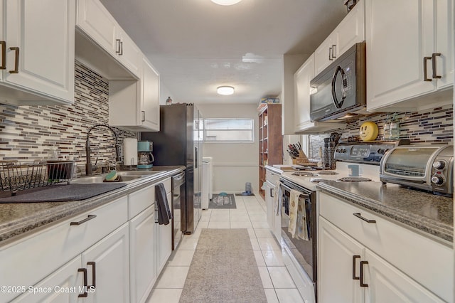 1032 Bernice Rd, Rockledge, FL 32955 - kitchen featuring white electric range oven, black microwave, white cabinetry, and tasteful backsplash