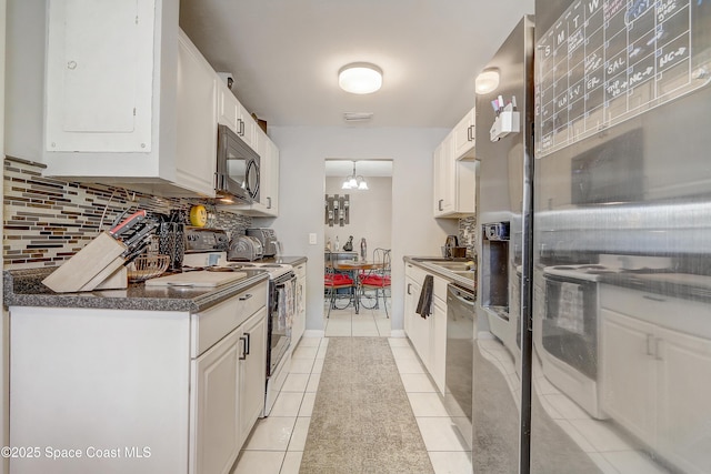 1032 Bernice Rd, Rockledge, FL 32955 - kitchen with black microwave, range with electric stovetop, tasteful backsplash, white range with electric stovetop, and white cabinets