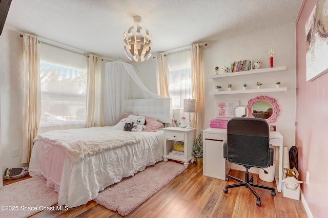 1032 Bernice Rd, Rockledge, FL 32955 - bedroom featuring light wood-style flooring, a textured ceiling, and a chandelier