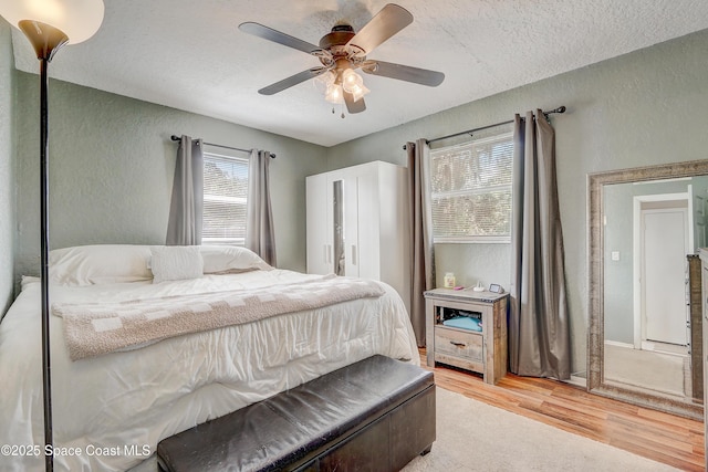 1032 Bernice Rd, Rockledge, FL 32955 - bedroom featuring a textured wall, light wood-type flooring, a textured ceiling, and a ceiling fan