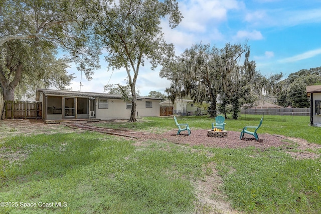 1032 Bernice Rd, Rockledge, FL 32955 - fenced backyard with an outdoor fire pit and a sunroom