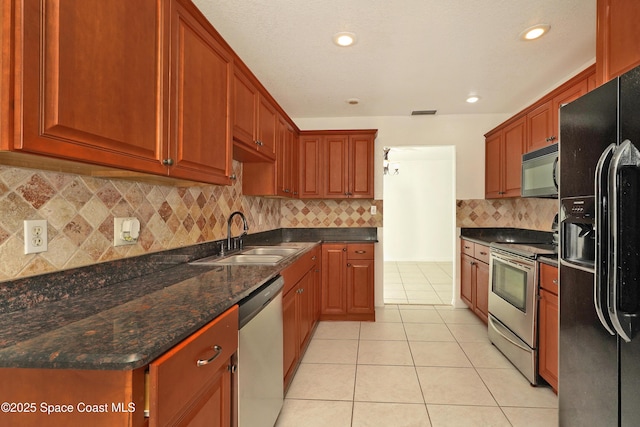 765 Palm Dr, Satellite Beach, FL 32937 - kitchen with appliances with stainless steel finishes, light tile patterned floors, decorative backsplash, dark stone counters, and recessed lighting