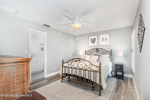 658 Hibiscus Dr, Satellite Beach, FL 32937 - bedroom with wood finished floors, a textured ceiling, connected bathroom, and a ceiling fan