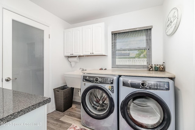 658 Hibiscus Dr, Satellite Beach, FL 32937 - laundry area with washer and clothes dryer, light wood finished floors, and cabinet space