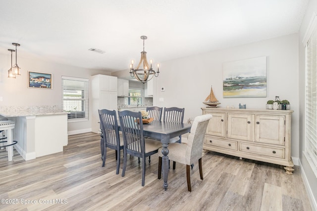 658 Hibiscus Dr, Satellite Beach, FL 32937 - dining space featuring light wood-style flooring and a chandelier